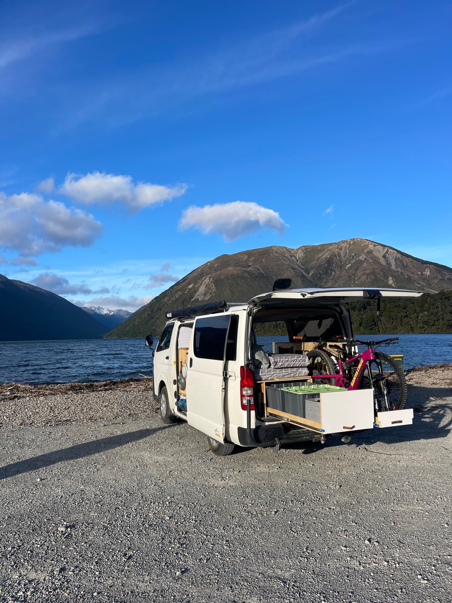 Marvin, the 4x4, parked with tailgate open and bikes loaded beside a lake in New Zealand